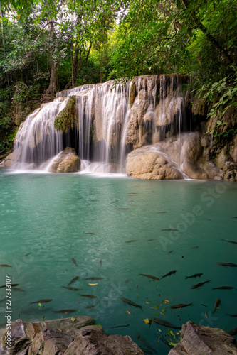 Clean green emerald water from the waterfall Surrounded by small trees - large trees,  green colour,  fish live in the pond, Erawan waterfall, Kanchanaburi province, Thailand