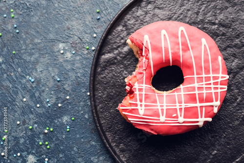 Pink frosted donut on dark background