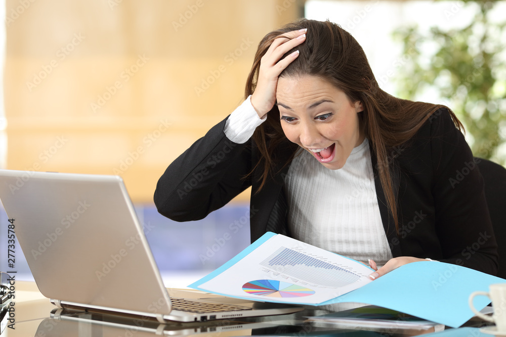 Excited businesswoman checking chart at office Excited businesswoman checking chart at office