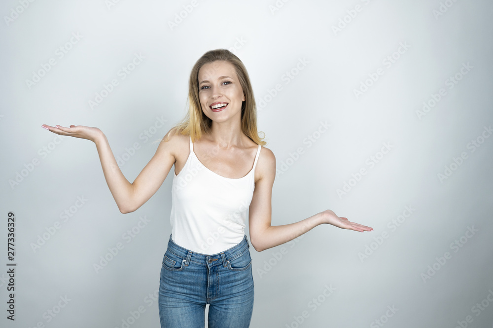 young beautiful woman smiling showing scales sign isolated white background young beautiful woman smiling showing scales sign isolated white background