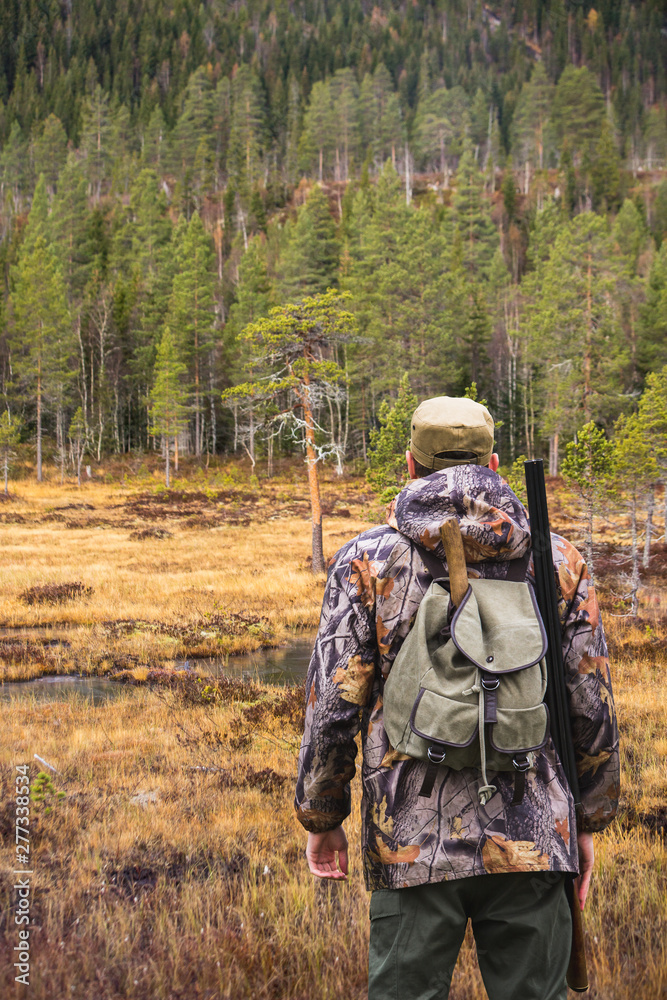 Hunter with a backpack and a gun