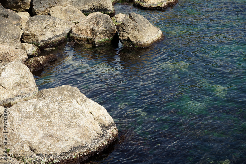 large stones in the water by the sea