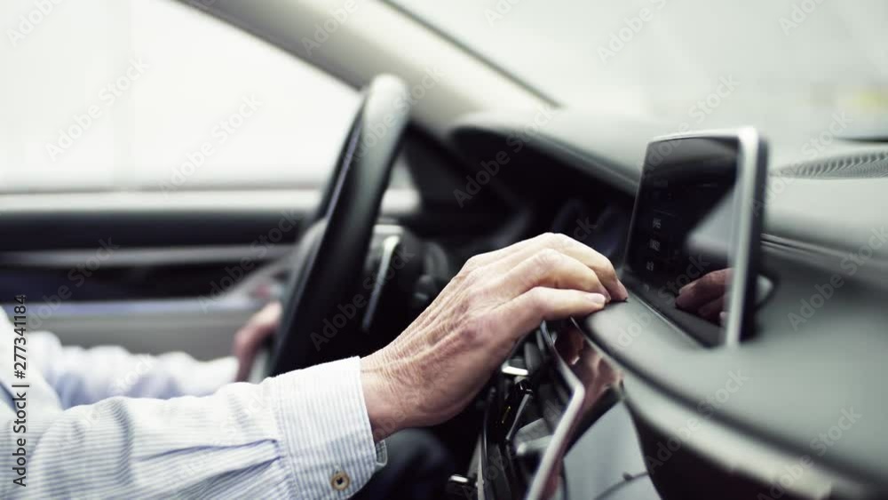 Midsection of man driver sitting in car, setting radio or navigation. Midsection of man driver sitting in car, setting radio or navigation.