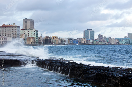 Crashing waves on a bright day breaking against The Malecon seawall Havana Cuba © akturer