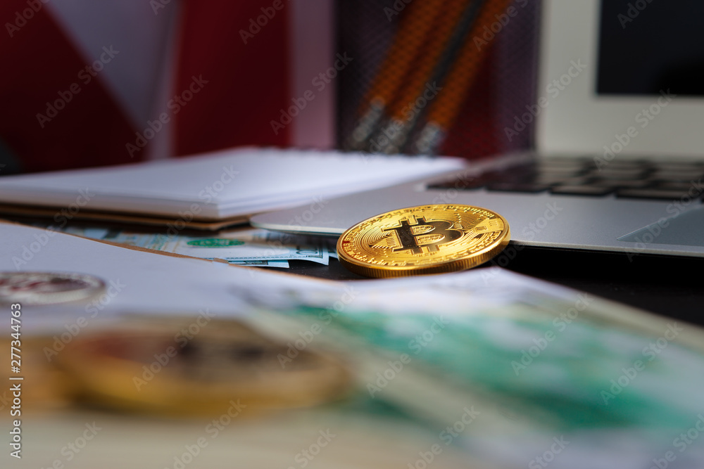 golden bitcoin coin on us dollars close up. Electronic crypto currency golden bitcoin coin on us dollars close up. Electronic crypto currency