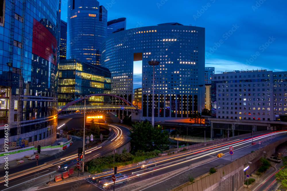 Obraz premium Evening Traffic Between Modern Buildings