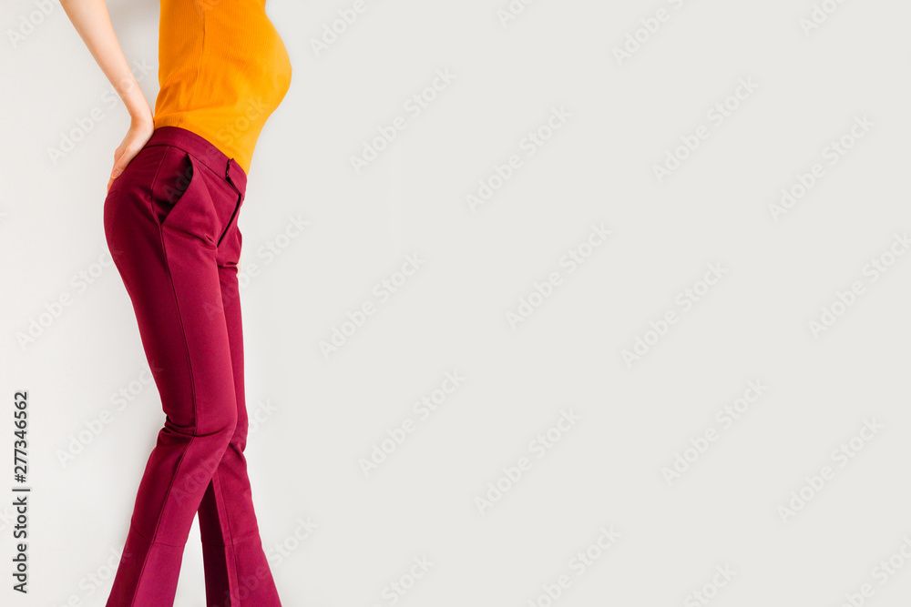 a woman in an orange shirt and red pants standing in front of an orange  wall generative ai 28378945 Stock Photo at Vecteezy