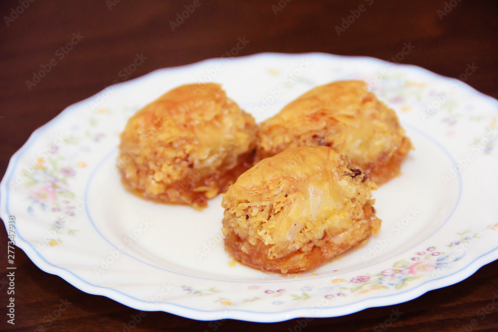 traditional Turkish puff sweetness baklava with nuts on white plate