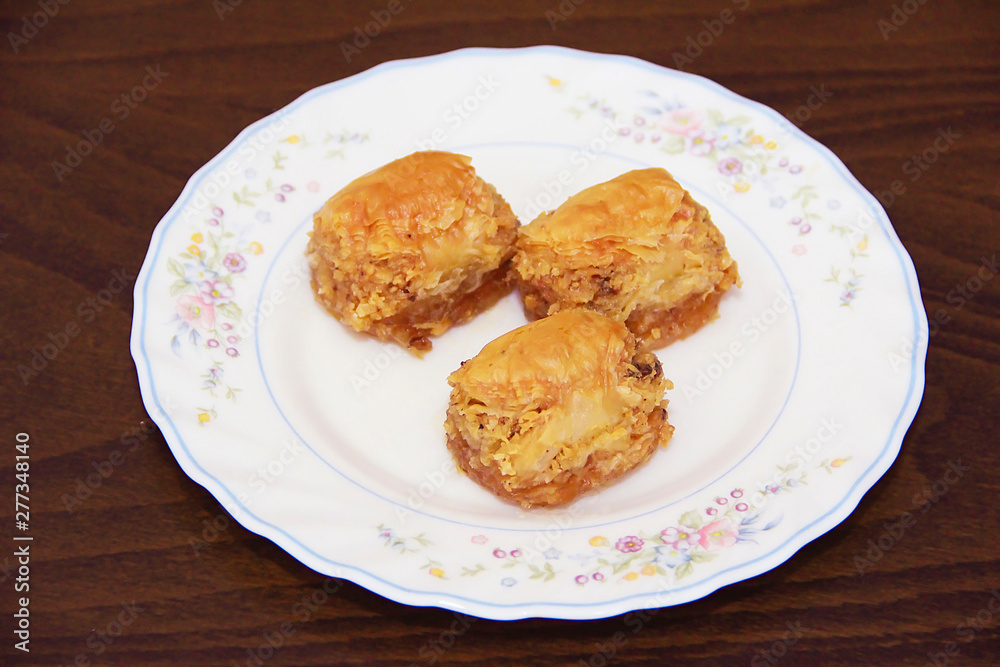 traditional Turkish puff sweetness baklava with nuts on white plate