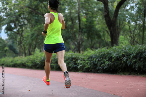 Fitness sporty woman jogger running at outdoors jogging track in park