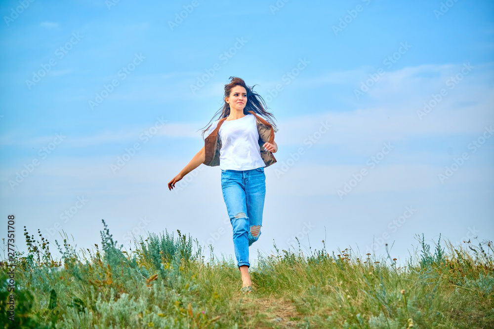 Girl in cowboy dress standing back on the top of Caucasus mountain with a scenery view to sunset at green valley. Female travel nature concept. Girl in cowboy dress standing back on the top of Caucasus mountain with a scenery view to sunset at green valley. Female travel nature concept.