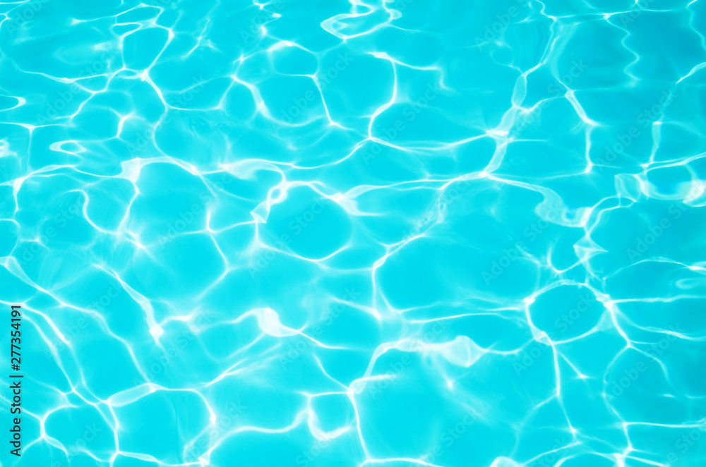 Bright blue water in the pool with a sun glare. Background image, water texture. The concept of swimming in the pool, recreation. Place for text.