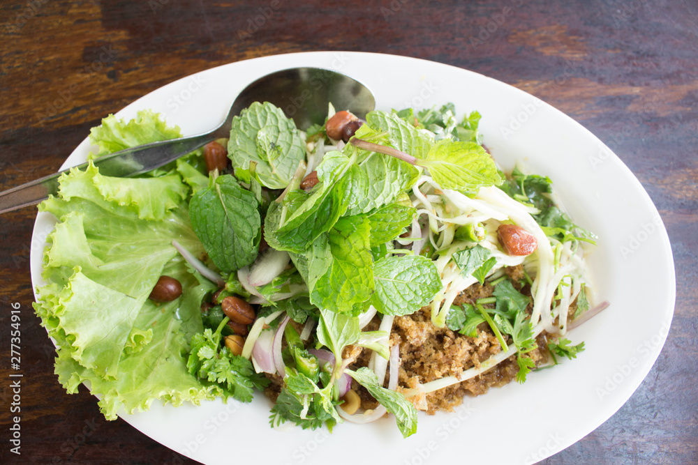 mint leaf on spicy fried catfish salad on white dish mint leaf on spicy fried catfish salad on white dish