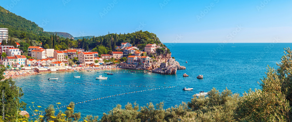 Picturesque summer view of Adriatic sea coast in Budva Riviera. Przno village with buildings on the rock, Montenegro - obrazy, fototapety, plakaty 