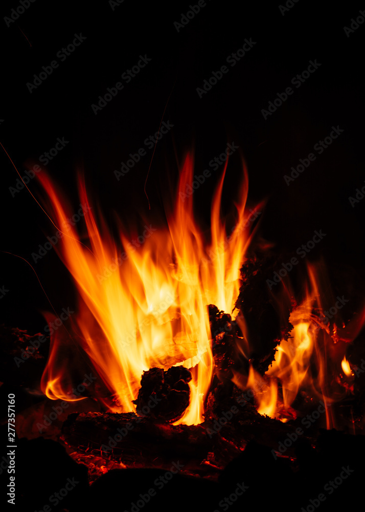Camp fire in the night, bright flames, black background Camp fire in the night, bright flames, black background