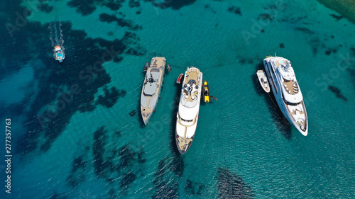Aerial drone photo of luxury yachts docked in famous turquoise clear sea bay of Ornos, Mykonos island, Cyclades, Greece © aerial-drone