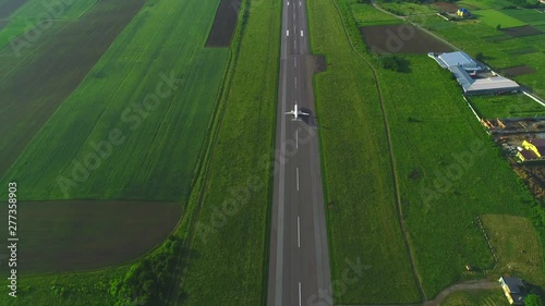 Aerial view of white plane launching from take off runaway in the air. 4K.