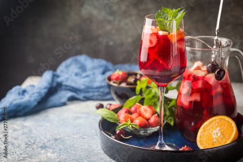 Red wine sangria or punch with fruits and ice in glasses and pincher. Homemade refreshing fruit sangria.