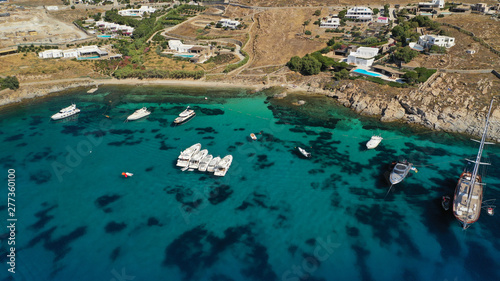 Aerial drone photo of luxury yachts docked in famous turquoise clear sea bay of Ornos, Mykonos island, Cyclades, Greece