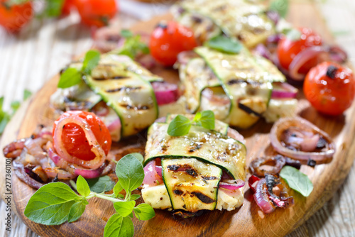 Vegetarisch grillen: Leckere griechische Feta-Zucchini-Päckchen  mit Zwiebeln und Kräutern sowie  Grilltomaten – Grilled Greek feta cheese wrapped in thin zucchini slices and onions photo