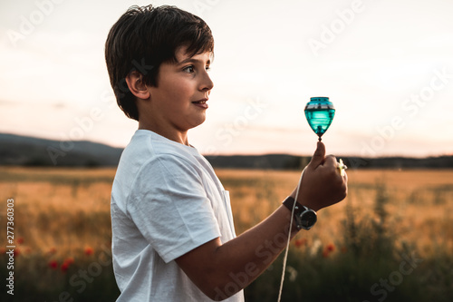 Foto Child playing spinning top. Concept of happy playing children