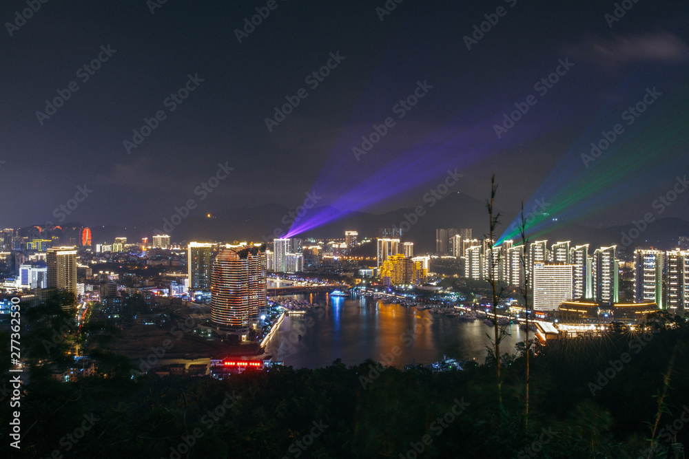 Panorama of night city, sea and buildings of hotels Phoenix Island Resort Sanya