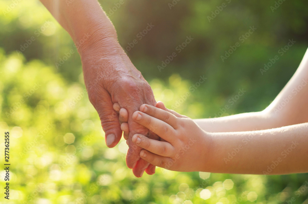 Childs hand and old hand grandmother. Concept idea of love family protecting children and elderly people grandmother friendship togetherness relationship Two generation.