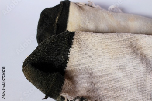 The socks are full of dust and dirt in the low light on a white background