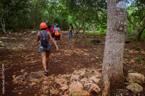 Turistas caminando por un sendero pedregoso en medio de la selva. Gente guiada en excursión.