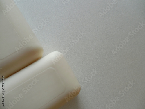  Two pieces of square white soap on the side on a white background