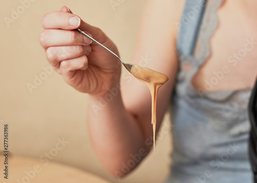 Woman holding spoon with peanut butter