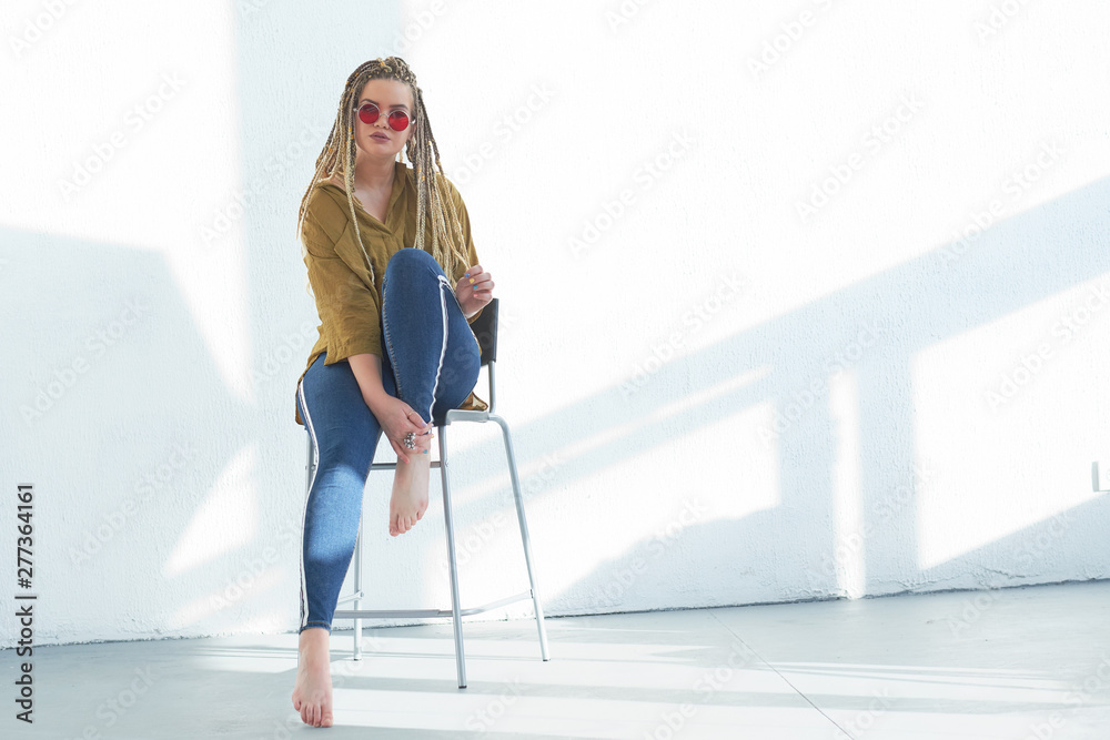Portrait of beautiful plus size girl sitting in the chair on white background Portrait of beautiful plus size girl sitting in the chair on white background