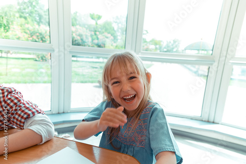 Happy blonde girl sitting at the table