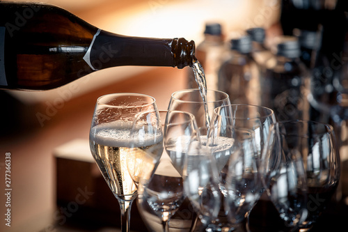 Sparkling wine is poured into a glass at a party