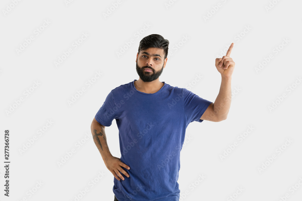 Beautiful male half-length portrait isolated on white studio background. Young emotional hindu man in blue shirt. Facial expression, human emotions, advertising concept. Pointing and choosing. Beautiful male half-length portrait isolated on white studio background. Young emotional hindu man in blue shirt. Facial expression, human emotions, advertising concept. Pointing and choosing.