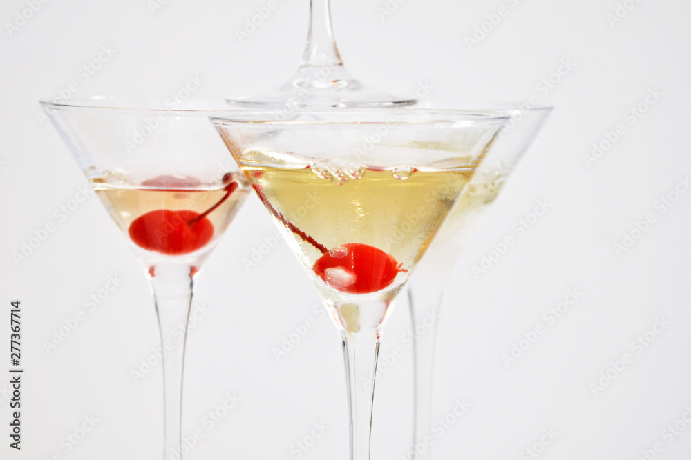 Three martini glasses, filled with champagne with cherries and liquid nitrogen, creating steam, in the shape of pyramid Three martini glasses, filled with champagne with cherries and liquid nitrogen, creating steam, in the shape of pyramid
