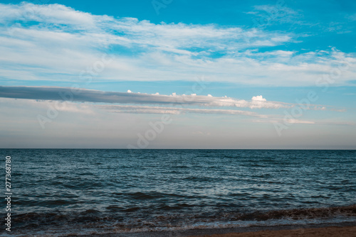 Sea with small waves and a beautiful sky in the evening.