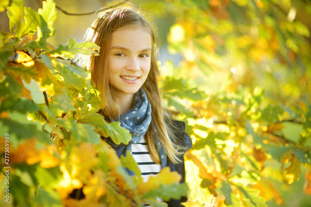 Adorable young girl having fun on beautiful autumn day. Happy child playing in autumn park. Kid gathering yellow fall foliage. Adorable young girl having fun on beautiful autumn day. Happy child playing in autumn park. Kid gathering yellow fall foliage.