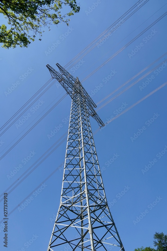 Strommast mit Leitungen vor blauem Himmel Strommast mit Leitungen vor blauem Himmel