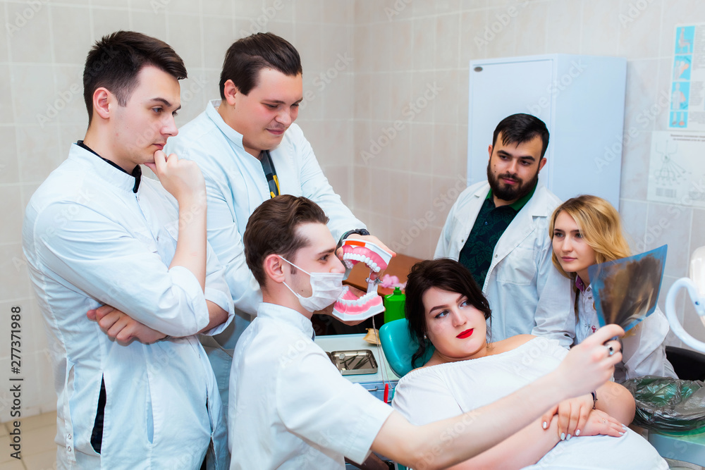 Dental clinic. A group of professional doctors discusses dental treatment on x-rays in the office. Modern Medical Education. Dental clinic. A group of professional doctors discusses dental treatment on x-rays in the office. Modern Medical Education.