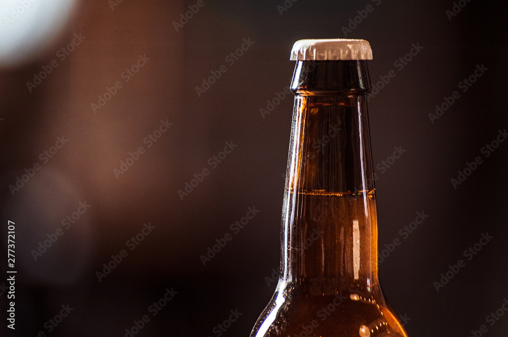 Brown ice cold beer bottle with water drops
