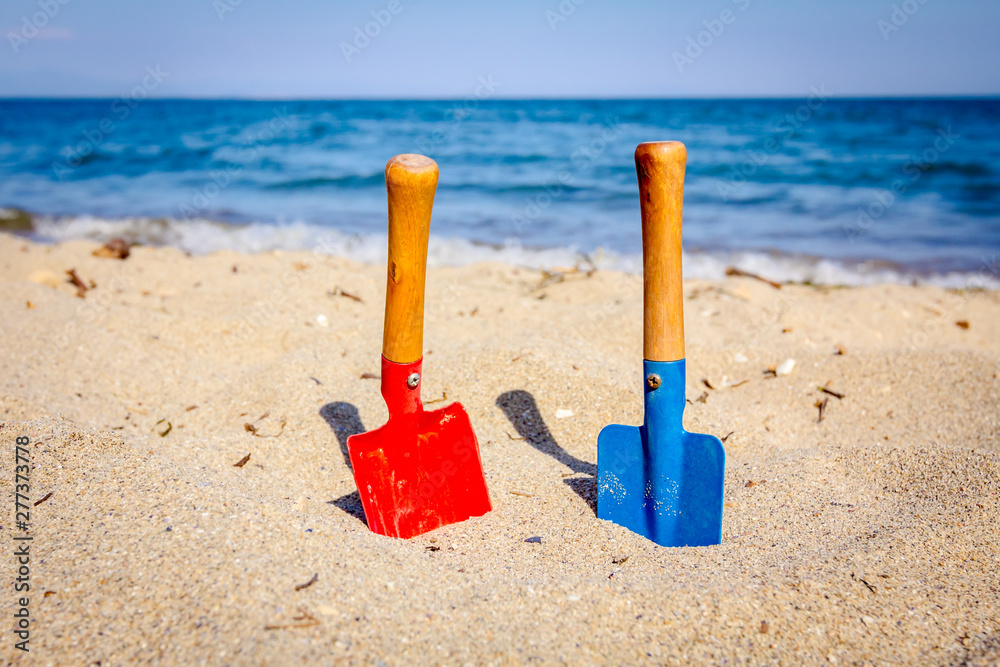 Small spade and shovel for digging sand on the beach. Small spade and shovel for digging sand on the beach.