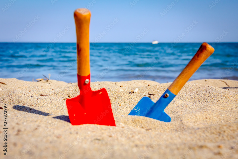 Small spade and shovel for digging sand on the beach. Small spade and shovel for digging sand on the beach.