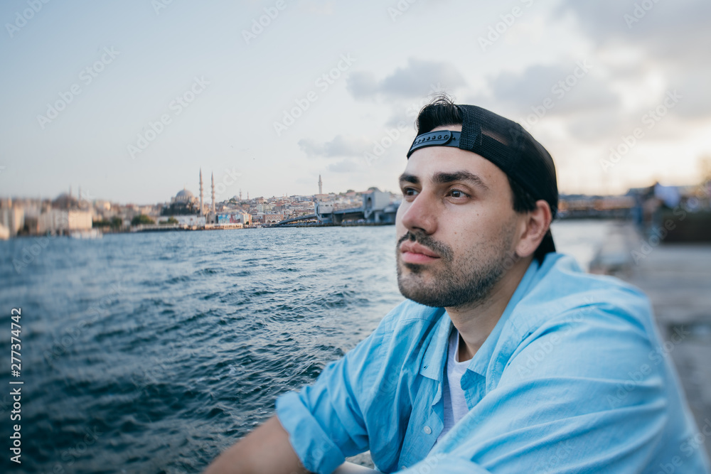 Portrait of a young man against the background of the sea and the city. Portrait of a young man against the background of the sea and the city.