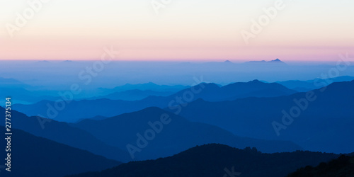 Poonhill view of mountains around Annapurnas. Warm pink and orange sunrise light over Annapurna mountain range with blue sky and beautiful clouds, Morning on Poon hill in Himalayas, Nepal. photo