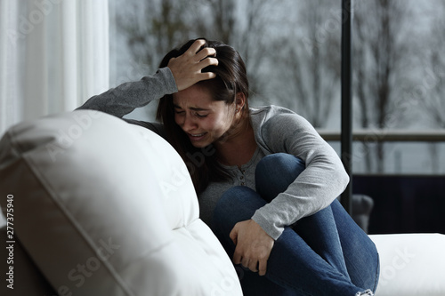 Sad woman complaining and crying at home
