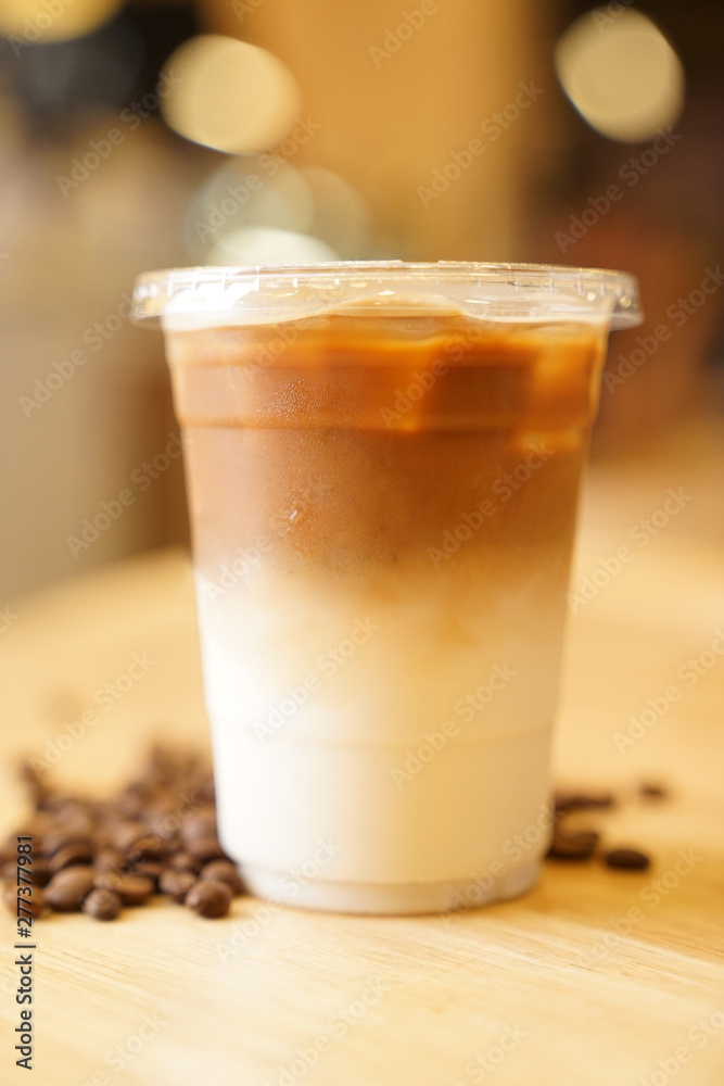 Take away Latte with Coffee bean around on the wood table Take away Latte with Coffee bean around on the wood table