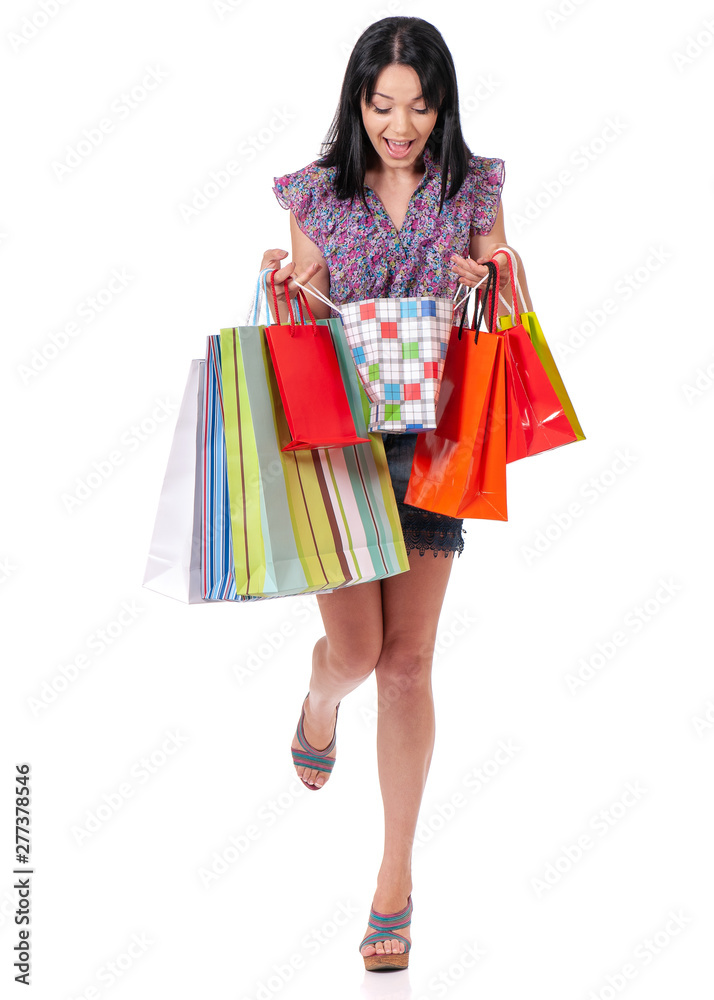 Full length portrait of young shopaholic shopping woman holding many shopping bags, isolated over white background