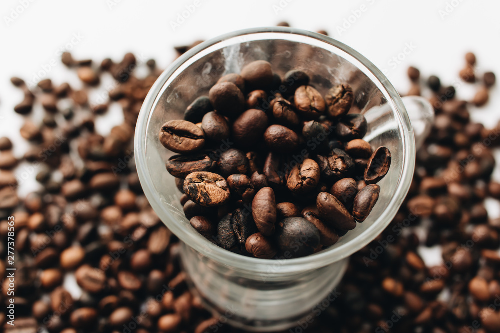 Fototapeta premium Close-up view of roasted coffee beans and glass cup 