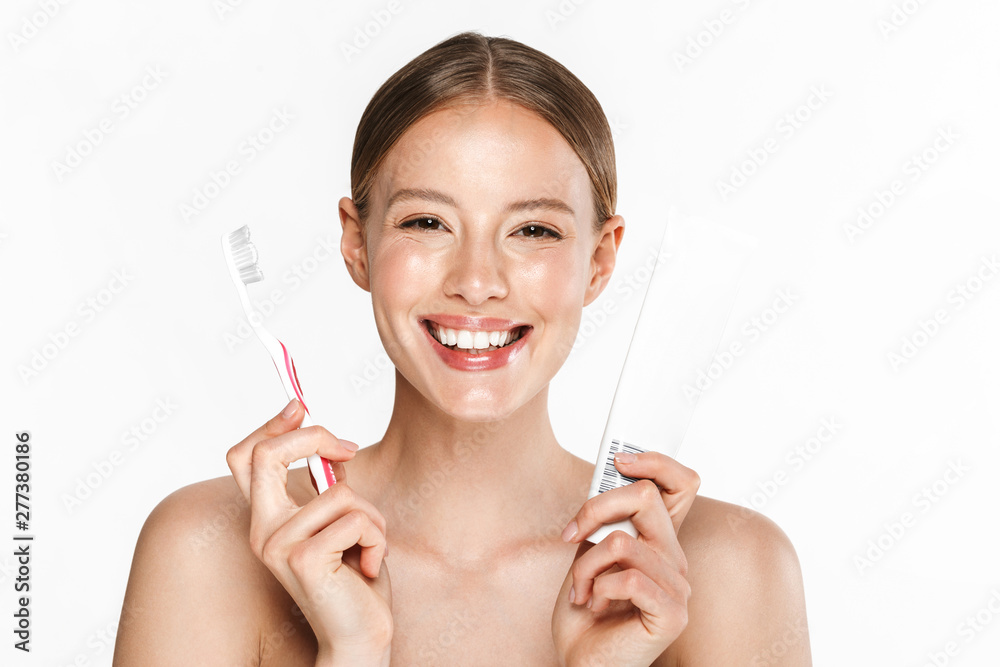 Image of smiling half-naked woman holding toothpaste and toothbrush Image of smiling half-naked woman holding toothpaste and toothbrush